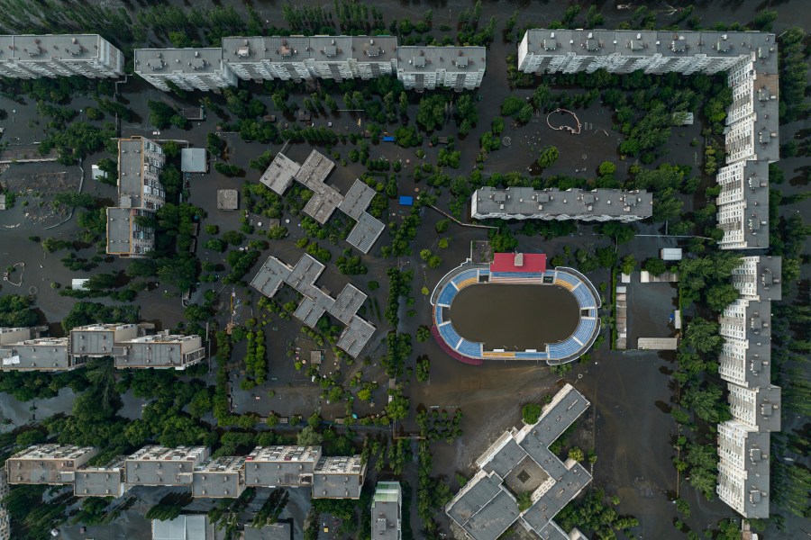 Houses and stadium are seen underwater and polluted by oil in the flooded Kherson, Ukraine, Saturday, June 10, 2023. The destruction of the Kakhovka Dam in southern Ukraine is swiftly evolving into long-term environmental catastrophe. It affects drinking water, food supplies and ecosystems reaching into the Black Sea. (AP Photo)