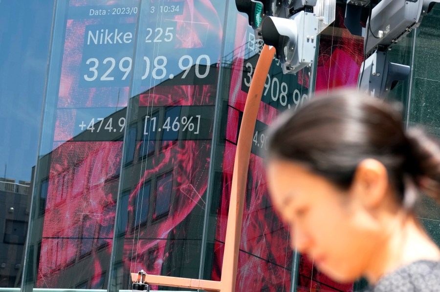 A person stands in front of an electronic stock board showing Japan's Nikkei 225 index at a securities firm Tuesday, June 13, 2023, in Tokyo. Asian stock markets were mostly higher Tuesday ahead of a U.S. inflation update and a Federal Reserve decision on another possible interest rate hike. (AP Photo/Eugene Hoshiko)