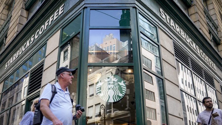 Pedestrians pass a Starbucks in the Financial District of Lower Manhattan, Tuesday, June 13, 2023, in New York. Starbucks is denying union organizers' claims that it banned LGBTQ+ Pride displays in its U.S. stores after Target and other brands experienced backlash. The Seattle coffee giant says there has been no change to its policy and it encourages store leaders to celebrate Pride in June. (AP Photo/John Minchillo)