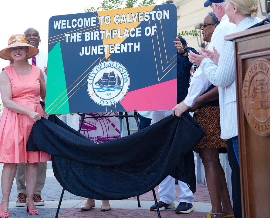 Members of the City of Galveston government unveil new signage that will be installed on the highway entering the Island to recognize its place as the birthplace of Juneteenth on Friday, June 16, 2023 in Galveston, Texas. (Elizabeth Conley/Houston Chronicle via AP)