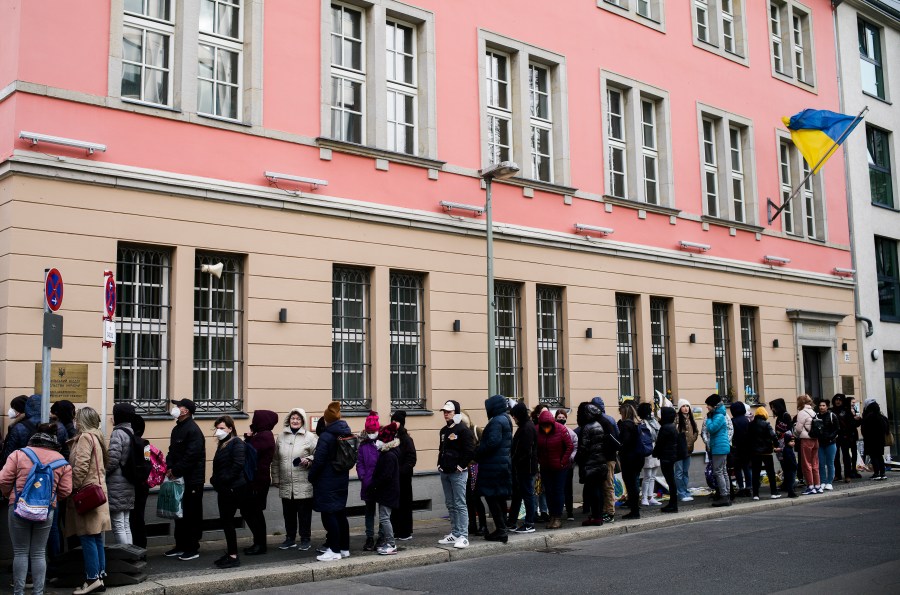 FILE -People from Ukraine, most of them refugees fleeing the war, wait in front of the consular department of the Ukrainian embassy in Berlin, Germany, on April 1, 2022. Large numbers of refugees from Ukraine fueled a 1.3% rise in the German population last year, helping push up the number of inhabitants in the European Union's most populous country to more than 84.4 million, official statistics showed Tuesday, June 20, 2023. (AP Photo/Markus Schreiber, File)