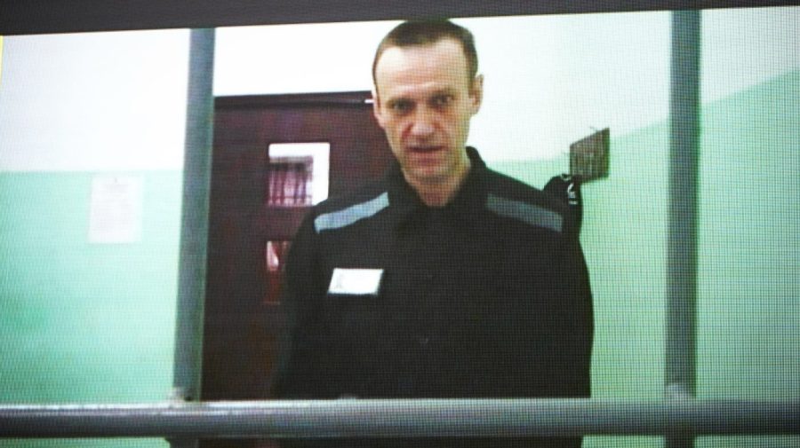 Russian opposition leader Alexei Navalny is seen on a TV screen as he appears in a video link provided by the Russian Federal Penitentiary Service from the colony in Melekhovo, Vladimir region, during a hearing at the Russian Supreme Court in Moscow, Russia, Thursday, June 22, 2023. Navalny has filed a lawsuit contesting prison regulations that, according to him, allow prison officials to deprive him of stationery and pens, thus violating his right to file complaints against them. (AP Photo/Alexander Zemlianichenko)