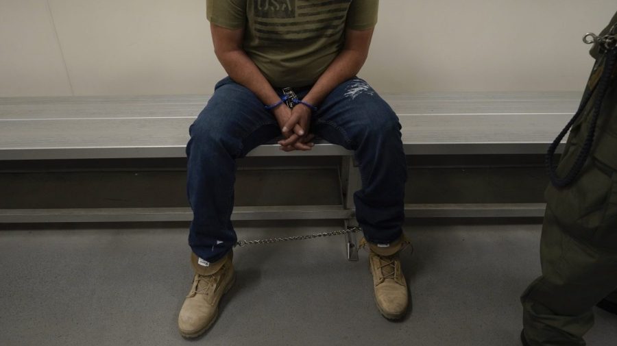 FILE - An immigrant considered a threat to public safety and national security waits to be processed by U.S. Immigration and Customs Enforcement agents at the ICE Metropolitan Detention Center in Los Angeles, after an early morning raid, June 6, 2022.