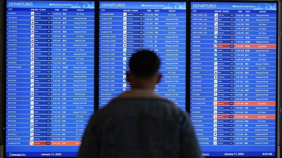 FILE - A traveler looks at a flight board with delays and cancellations at Ronald Reagan Washington National Airport in Arlington, Va., Wednesday, Jan. 11, 2023. Thousands of air travelers faced flight cancellations and delays this weekend as thunderstorms traveled across the U.S. East Coast and Midwest. (AP Photo/Patrick Semansky, File)