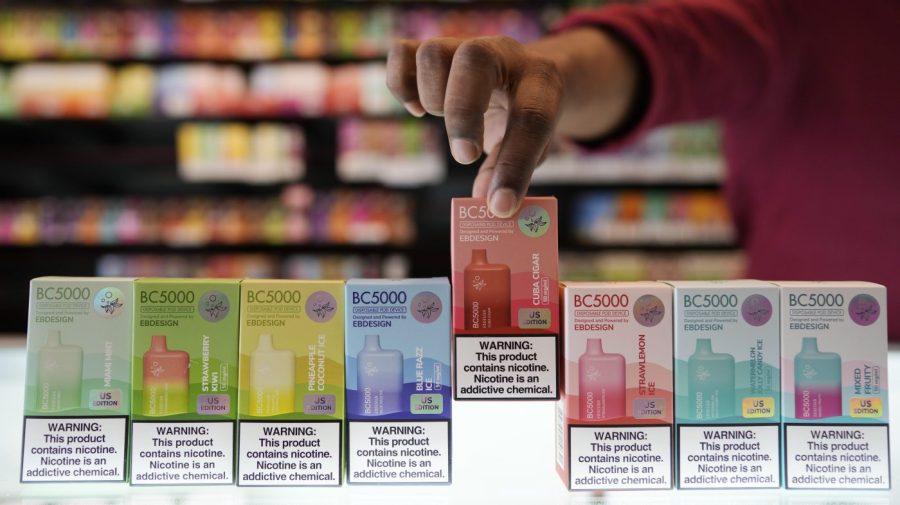 An employee displays some of the varieties of disposable electronic cigarette devices manufactured by EB Design, formerly known as Elf Bar, at Vapes N Smoke in Pinecrest, Fla., Monday, June 26, 2023. Since 2020, the number of different e-cigarette devices for sale in the U.S. has exploded to more than 9,000, a nearly three-fold increase driven almost entirely by a wave of disposable vapes from China. (AP Photo/Rebecca Blackwell)