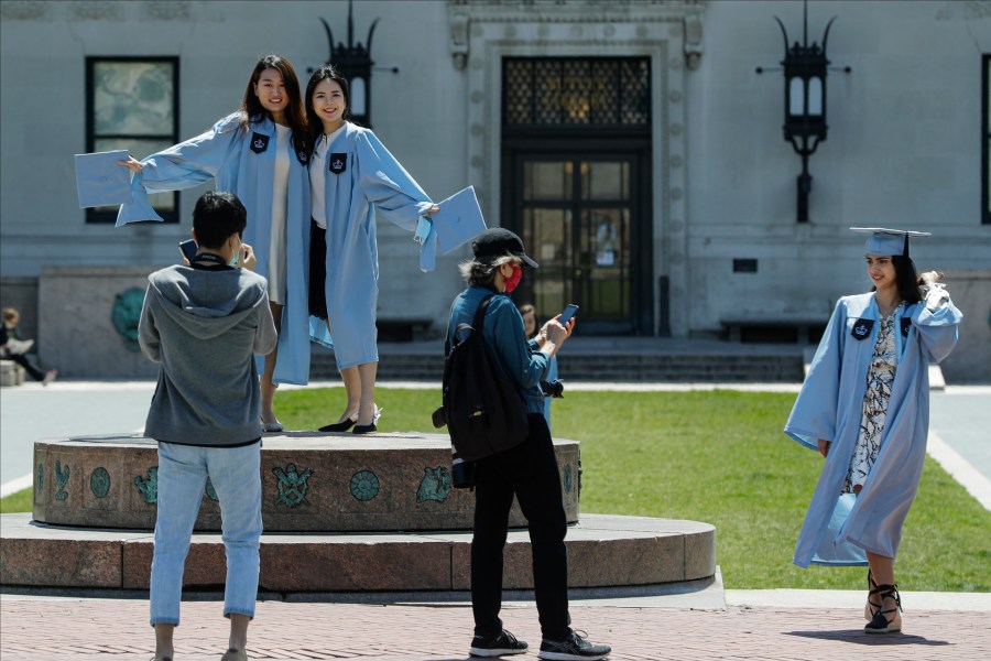 File - Columbia University class of 2020 graduates pose for photographs on Commencement Day on Wednesday, May 20, 2020, in New York. After three years, the pandemic-era freeze on student loan payments will end in late August. It might seem tempting to just keep not making payments, but the consequences can be severe, including a hit to your credit score and exclusion from future aid and benefits. (AP Photo/Frank Franklin II, File)