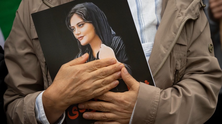 A portrait of Mahsa Amini is held during a rally calling for regime change in Iran following the death of Amini, a young woman who died after being arrested in Tehran by Iran's notorious "morality police," in Washington, on Oct. 1, 2022. (AP Photo/Cliff Owen, File)