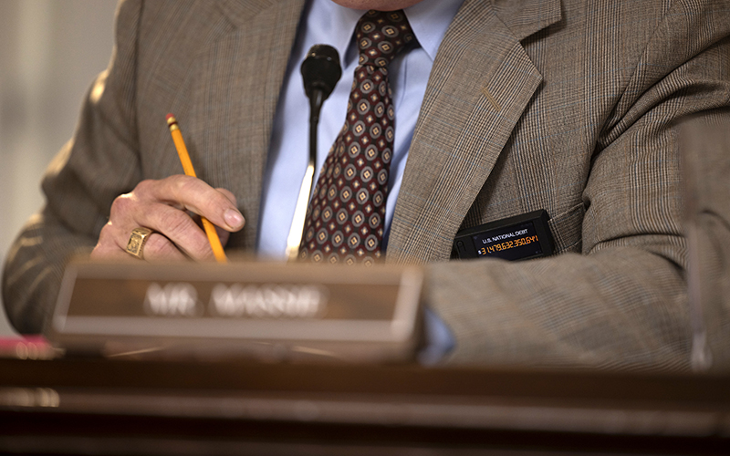 A closeup is shown of Rep. Thomas Massie's (R-Ky.) pin counting the national debt