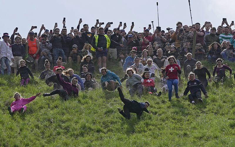 Participants compete in the women's downhill race during the May 29 Cooper's Hill Cheese-Rolling