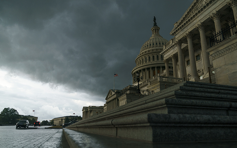 The U.S. Capitol is seen against a sky full of dark clouds as a rainstorm rolls in