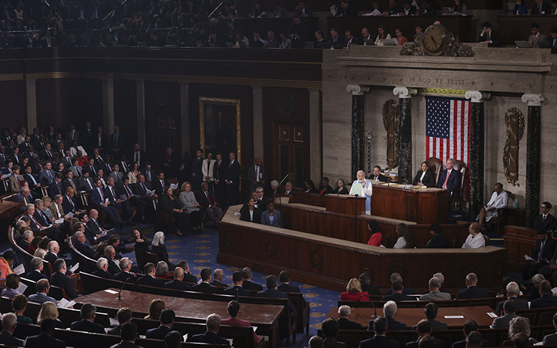 Indian Prime Minister Narendra Modi speaks during a joint meeting of Congress. The picture is taken from far away, showing the many attendees in the room listening to Modi, who is standing behind the podium.