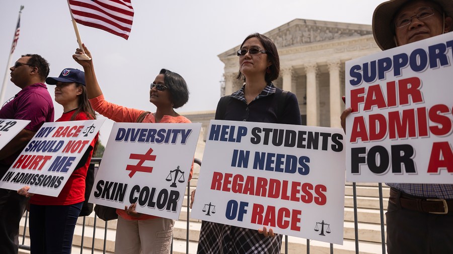 Demonstrators in support of the Supreme Court decision to strike down race-conscious student admissions programs at Harvard University and the University of North Carolina stand in front of the Supreme Court