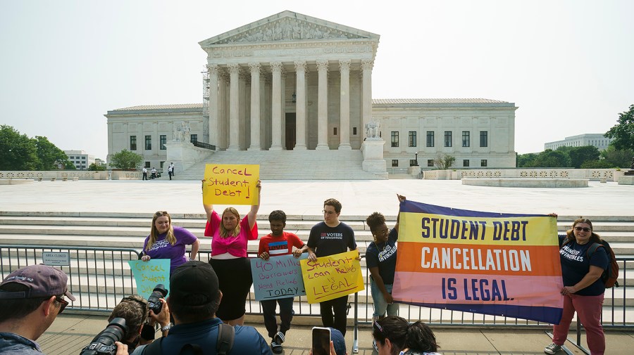 Supporters of student debt relief protest outside the Supreme Court with signs like "Cancel student debt" and "Student debt cancellation is legal."