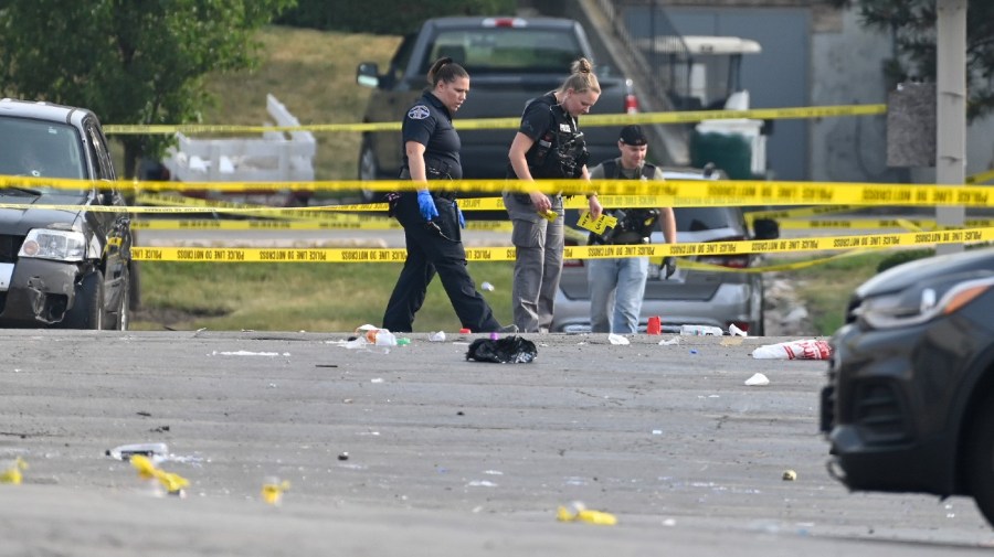 Investigators look over the scene of an overnight mass shooting at a strip mall in Willowbrook, Ill., Sunday, June 18, 2023.