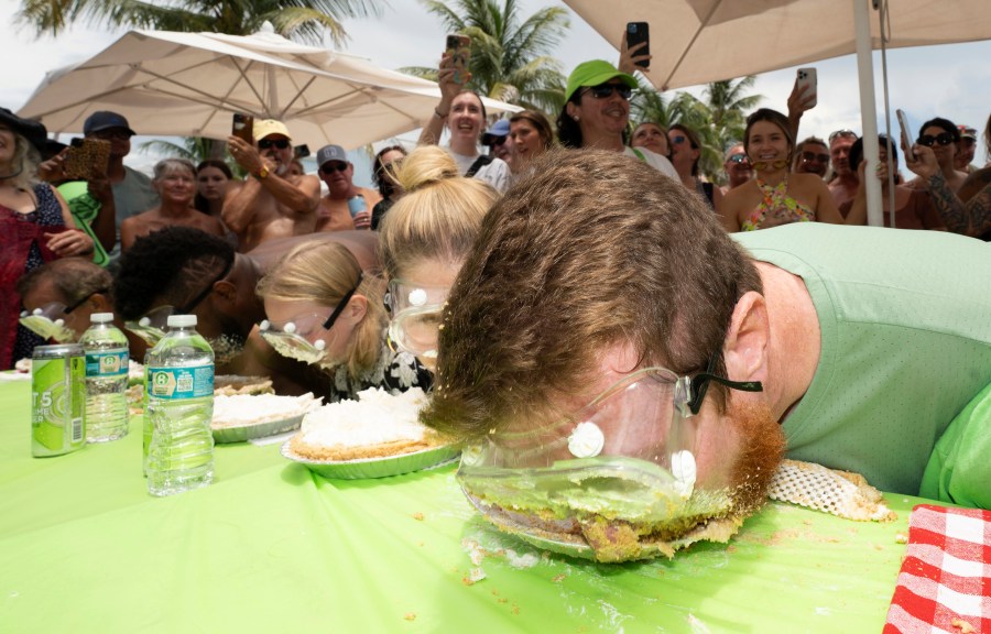 In this photo provided by the Florida Keys News Bureau, Joshua Mogle, right, of Altoona, Iowa, buries his face in a Key lime pie as he eats his way to victory at the World Famous Key Lime Pie Eating Championship Tuesday, July 4, 2023, in Key West, Fla. Mogle, a 38-year-old tire manufacturing manager, devoured the Florida Keys' signature dessert in three minutes and 35 seconds, the fastest time of 25 contestants. The gooey competition, whose entrants are forbidden to use their hands, has become a subtropical alternative to New York City's hot dog eating contest. (Rob O'Neal/Florida Keys News Bureau via AP)