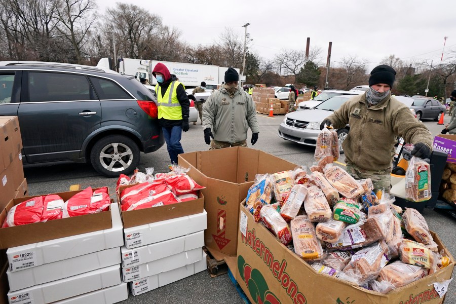 FILE - Sgt. Kevin Fowler organizes food at a food bank distribution by the Greater Cleveland Food Bank, Thursday, Jan. 7, 2021, in Cleveland. A new poll of Americans found that nearly half of those who stopped giving to charity over the past five years said they did so because they thought wealthier people could afford to give more — and should. Others said they simply could not afford to give. (AP Photo/Tony Dejak File)