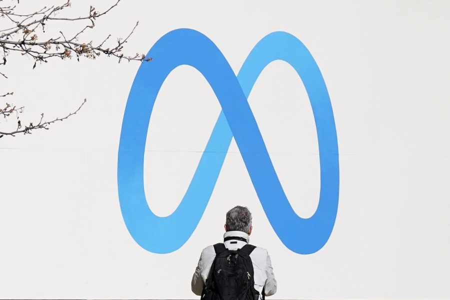 FILE - A person stands in front of a Meta sign outside of the company's headquarters in Menlo Park, Calif., Tuesday, March 7, 2023. Canada's government has announced on Wednesday July 5, that it will stop advertising on Facebook and Instagram in response to Meta’s decision to block access to news content on their social platforms as part of a temporary test. (AP Photo/Jeff Chiu, File)