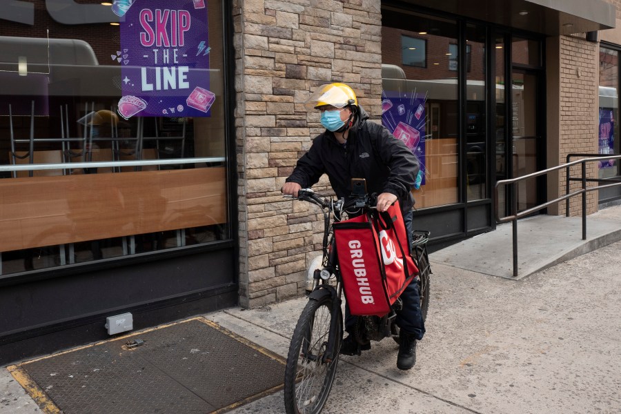 FILE - A delivery man bikes with a food bag from Grubhub on April 21, 2021, in New York. Uber Eats, DoorDash and Grubhub sued New York City on Thursday, July 6, 2023, to block its new minimum pay rules for food delivery workers. (AP Photo/Mark Lennihan, File)