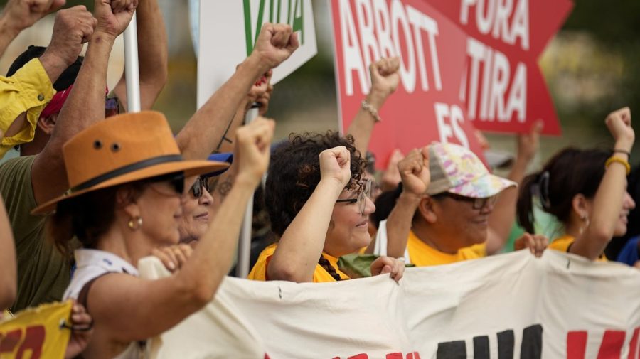 A group holds signs as they protest against buoys that are set to be deployed in the Rio Grande, Friday, July 7, 2023, in Eagle Pass, Texas, where border crossings continue to place stress on local resources. Advocates have raised concern that the barriers may have an adverse environmental impact. (AP Photo/Eric Gay)