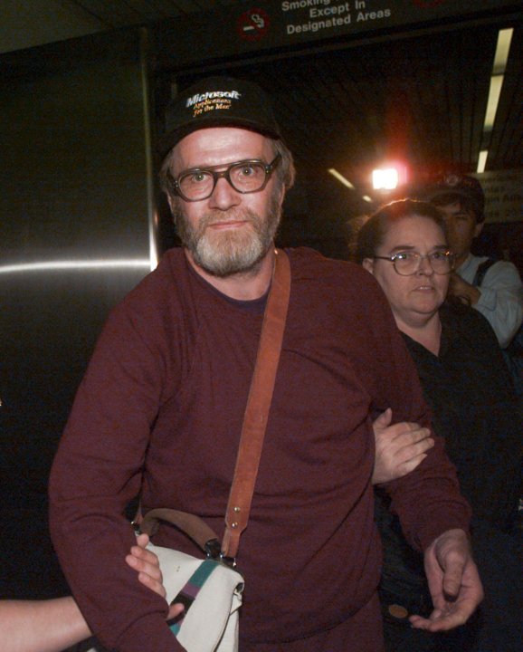 FILE — James Lewis is escorted through Boston's Logan Airport, Friday Oct. 13, 1995, after being released from the Federal Correctional Institution in Oklahoma. Lewis, the suspect in the 1982 Tylenol murders, was found dead Sunday, July 9, 2023 at his home in Cambridge, Mass., law-enforcement sources said. (AP Photo/Charles Krupa, File)