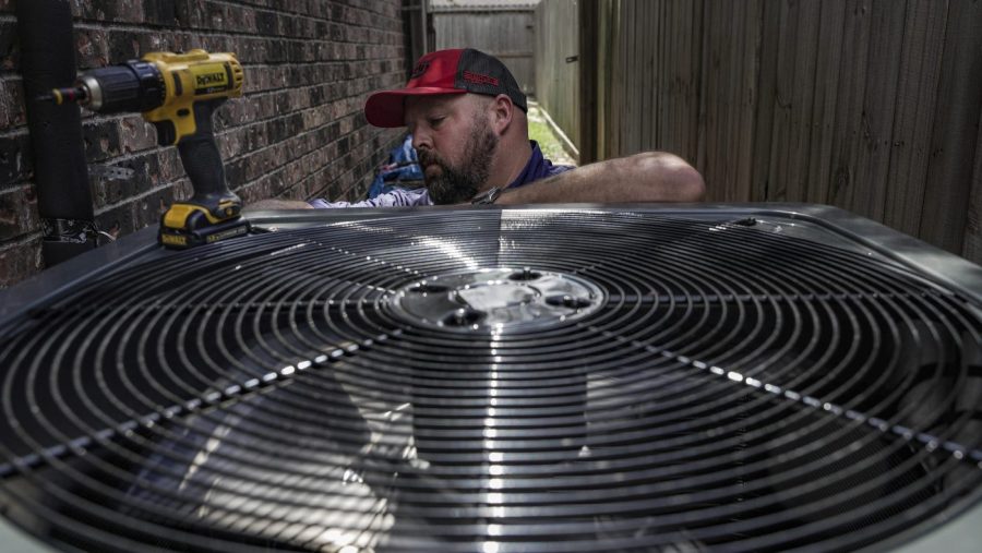 FILE - Ed Newby, owner of All Star A/C and Heating, works on an air conditioning unit on June 26, 2023, in Houston. The Environmental Protection Agency is enforcing stricter limits on hydrofluorocarbons, highly potent greenhouse gases used in refrigerators and air conditioners. A rule announced Tuesday, July 11, would impose a 40% reduction in HFCs below historic levels by 2028, part of a global phaseout of HFCs designed to slow global warming. (Raquel Natalicchio/Houston Chronicle via AP, File)