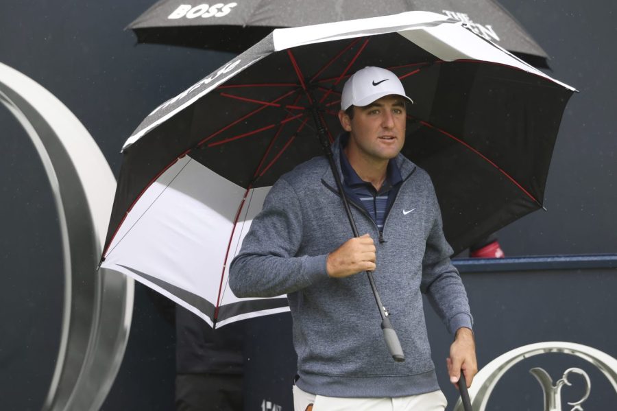 United States' Scottie Scheffler waits under an umbrella on the 1st tee as light rain falls during a practice round for the British Open Golf Championships at the Royal Liverpool Golf Club in Hoylake, England, Tuesday, July 18, 2023. The Open starts Thursday, July 20. (AP Photo/Peter Morrison)