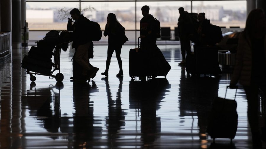 File - People pass through Salt Lake City International Airport on Wednesday, Jan. 11, 2023, in Salt Lake City, after a computer outage at the Federal Aviation Administration disrupted flights. This week, lawmakers will fight over how pilots are trained, how long they can work, and whether travelers will get more compensation for canceled and delayed flights. (AP Photo/Rick Bowmer, File)