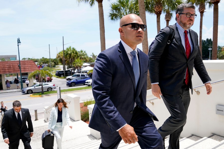 Walt Nauta, a valet to former President Donald Trump, left, arrives with defense attorney Stanley Woodward, right, at the Alto Lee Adams Sr. U.S. Courthouse for a pretrial conference to discuss procedures for handling classified information, Tuesday, July 18, 2023, in Fort Pierce, Fla. Nauta is charged with helping the ex-president hide classified documents the Justice Department wanted back. (AP Photo/Lynne Sladky)