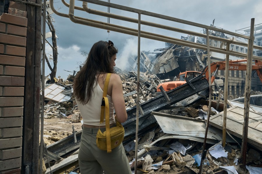 A woman watches as emergency service personnel work at the site of a destroyed building after a Russian attack in Odesa, Ukraine, Thursday, July 20, 2023. Russia pounded Ukraine’s southern cities, including the port city of Odesa, with drones and missiles for a third consecutive night in a wave of strikes that has destroyed some of the country’s critical grain export infrastructure. (AP Photo/Libkos)