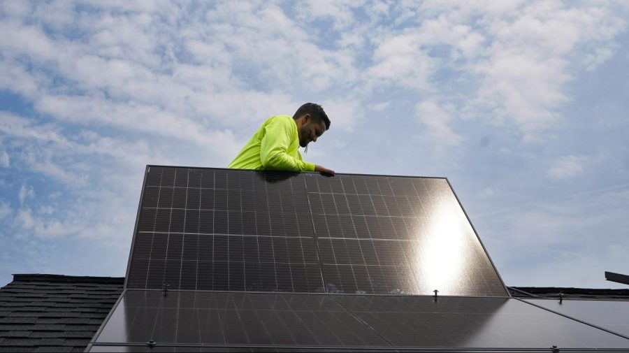 Nicholas Hartnett, owner of Pure Power Solar, places panel as his company installs a solar array on the roof of a home in Frankfort, Ky., Monday, July 17, 2023. Since passage of the Inflation Reduction Act, it has boosted the U.S. transition to renewable energy, accelerated green domestic manufacturing, and made it more affordable for consumers to make climate-friendly purchases, such as installing solar panels on their roofs. (AP Photo/Michael Conroy)