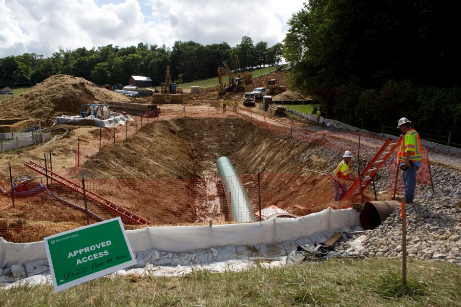 FILE - Construction crews bore beneath U.S. 221 in Roanoke County, Va., June 22, 2018, to make a tunnel through which the Mountain Valley Pipeline will pass under the highway. The state of West Virginia announced Monday, July 24, 2023, that it is appealing a ruling that blocked construction on a segment of the contentious natural gas pipeline being built through Virginia and West Virginia. (Heather Rousseau/The Roanoke Times via AP, File)