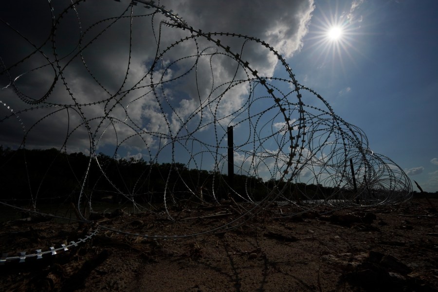 Concertina wire lines the banks of the Rio Grande on the Pecan farm of Hugo and Magali Urbina, near Eagle Pass, Texas, Monday, July 7, 2023. Texas Republican Gov. Greg Abbott has escalated measures to keep migrants from entering the U.S. He's pushing legal boundaries along the border with Mexico to install razor wire, deploy massive buoys on the Rio Grande and bulldozing border islands in the river. (AP Photo/Eric Gay)