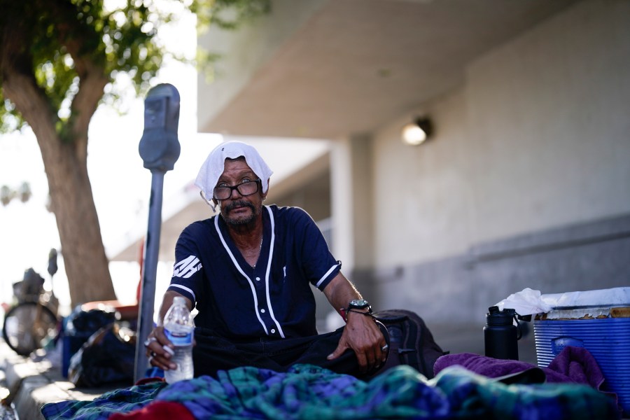 FILE - A man, who is homeless, drinks water as he wears a wet towel on his head, given to him by Maribel Padilla of the Brown Bag Coalition, July 20, 2023, in Calexico, Calif. Once temperatures hit 113 degrees Fahrenheit (45 Celsius), Padilla and the Brown Bag Coalition meet up with people who are homeless in Calexico, providing them with a cold, wet towel, and some refreshments to help them endure the scorching temperatures. (AP Photo/Gregory Bull, File)