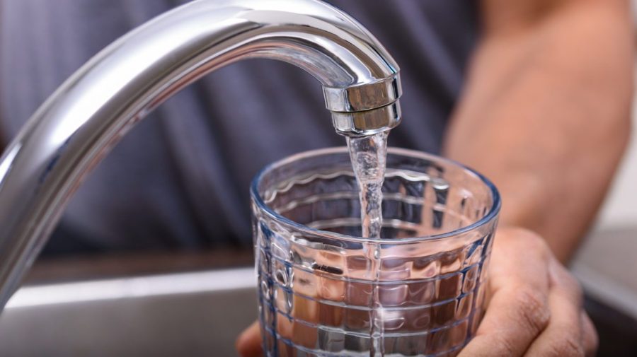 A person fills a glass with tap water.