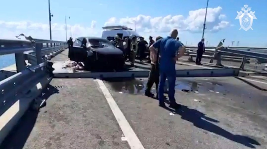 In this handout photo taken from video released by Investigative Committee of Russia on Monday, July 17, 2023, investigators work at an automobile link of the Crimean Bridge connecting Russian mainland and Crimean peninsula over the Kerch Strait not far from Kerch, Crimea.