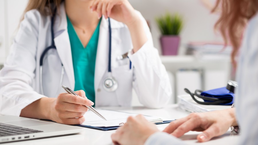 A close up of the hands of a doctor and patient during a consultation