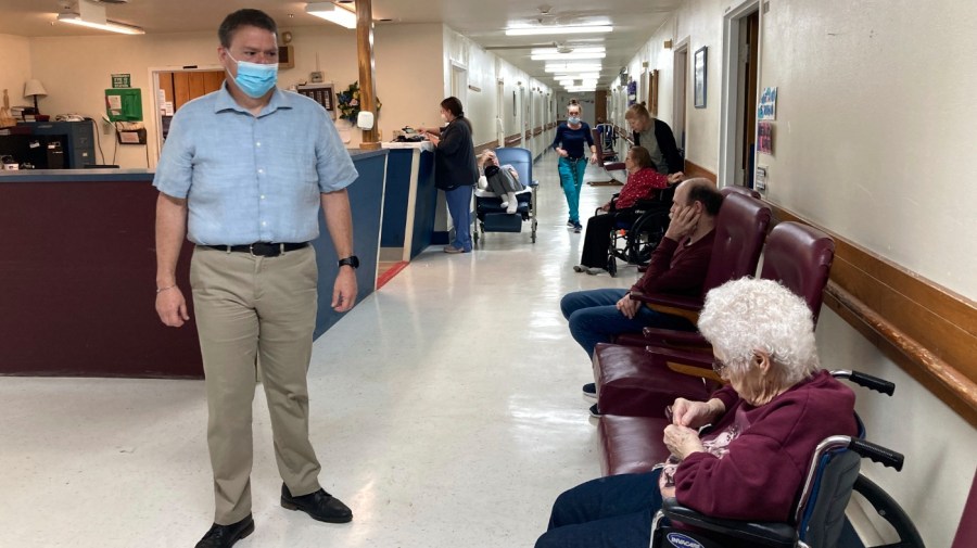 Tim Corbin, left, the administrator of Truman Lake Manor, passes through the hallway of the nursing home on Feb. 14, 2023, in Lowry, Mo. (AP Photo/David A. Lieb)