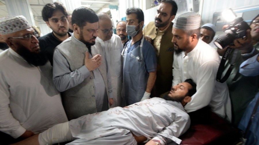 People transport an injured victim of a powerful bomb upon arrival at a hospital in Peshawar, Pakistan, Sunday, July 30, 2023.