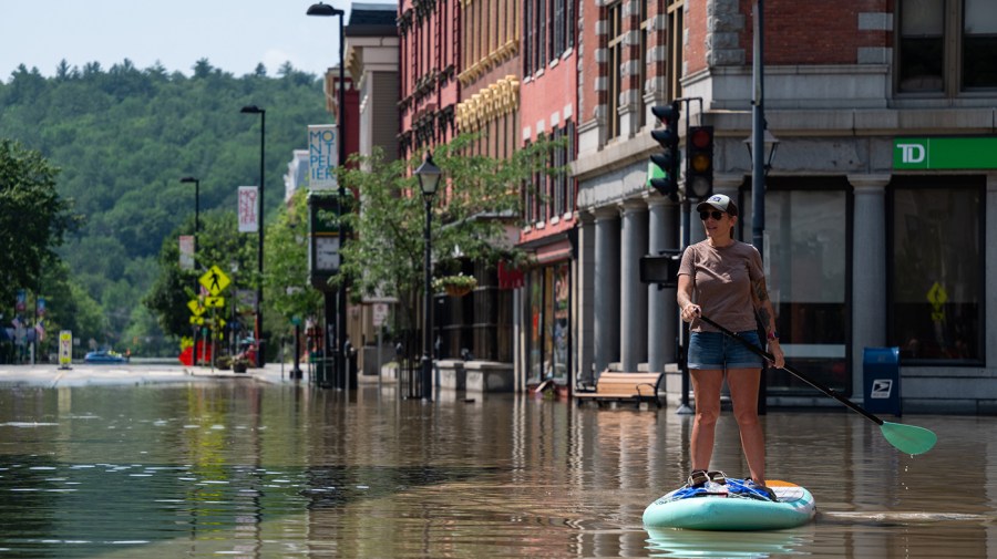 Montpelier resident Lynnea Timpone paddle boards through a city intersection