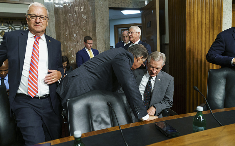 Sens. Joe Manchin (D-W.Va.) speaks with Tommy Tuberville (R-Ala.) as they arrive for a Senate Armed Services Committee nomination hearing