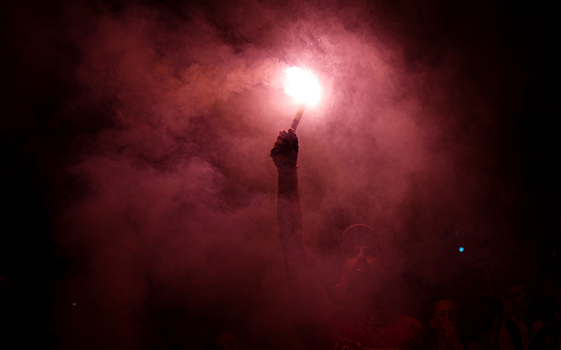 An Israeli activist burns a flare