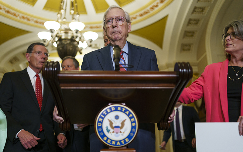 Minority Leader Mitch McConnell (R-Ky.) unexpectedly pauses while speaking to reporters, as the senators flanking him approach with concern