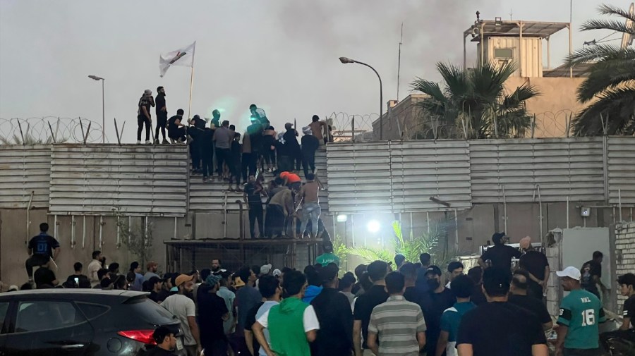 Protesters scale a wall at the Swedish Embassy in Baghdad Thursday, July 20, 2023.