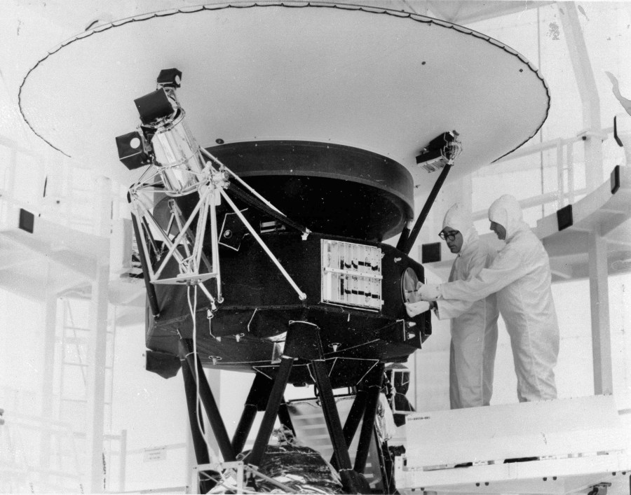 FILE - In this Aug. 4, 1977, photo provided by NASA, the "Sounds of Earth" record is mounted on the Voyager 2 spacecraft in the Safe-1 Building at the Kennedy Space Center, Fla., prior to encapsulation in the protective shroud. After days of silence, NASA has heard from Voyager 2, more than 12 billion miles away in interstellar space. Flight controllers accidentally sent a wrong command nearly two weeks ago that tilted the spacecraft's antenna away from Earth and severed contact. The project manager said Tuesday, Aug. 1, 2023 that the fact that the Deep Space Network has picked up a “heartbeat signal” means the 46-year-old craft is alive and operating. (AP Photo/NASA, File)