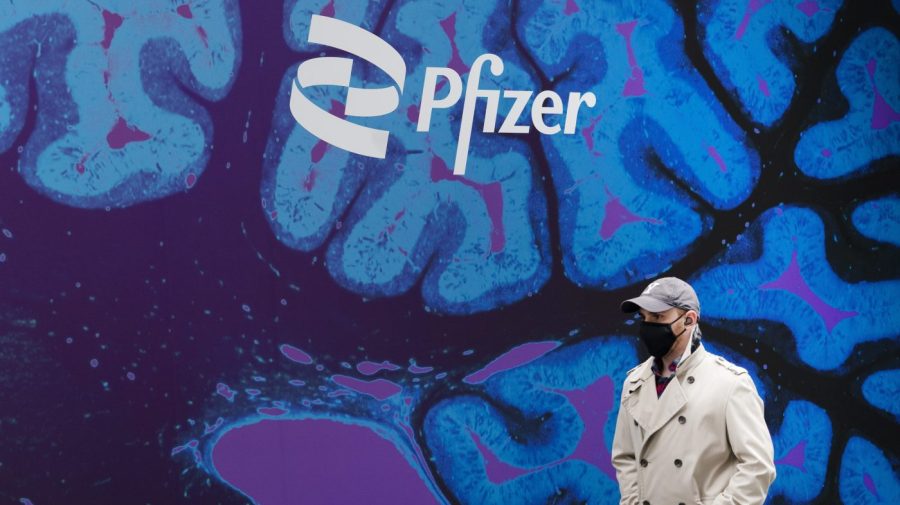 FILE - A man walks by Pfizer headquarters, Friday, Feb. 5, 2021, in New York. Pfizer reports reports earnings on Tuesday, Aug. 1, 2023. (AP Photo/Mark Lennihan, File)