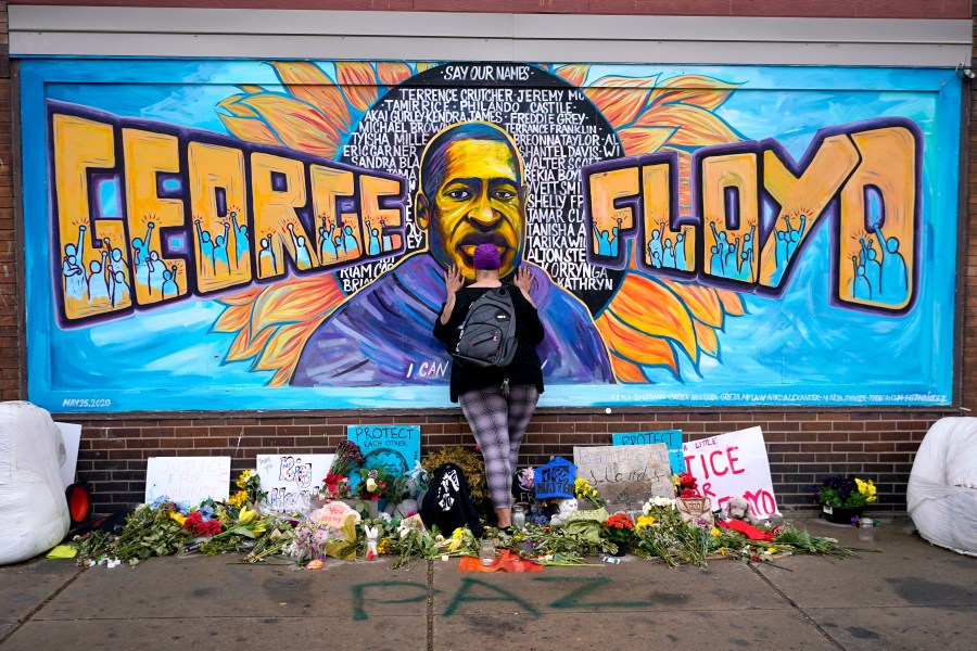 FILE - Damarra Atkins pays respect to George Floyd at a mural at George Floyd Square in Minneapolis, April 23, 2021. Tou Thao, the last former Minneapolis police officer convicted in state court for his role in the killing of George Floyd, has been sentenced to 4 years and 9 months on Monday, Aug. 7, 2023, even as he denied wrongdoing. (AP Photo/Julio Cortez, File)