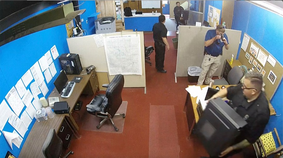 This surveillance video shows Marion Police Department confiscating computers and cellphones from the publisher and staff of the Marion County Record on Friday, Aug. 11, 2023 in Marion, Kan. The small newspaper and the police department in Kansas are at the center of a dispute over freedom of speech that is being watched around the country after police raided the office of the local newspaper and the home of its owner and publisher. (Marion County Record via AP)