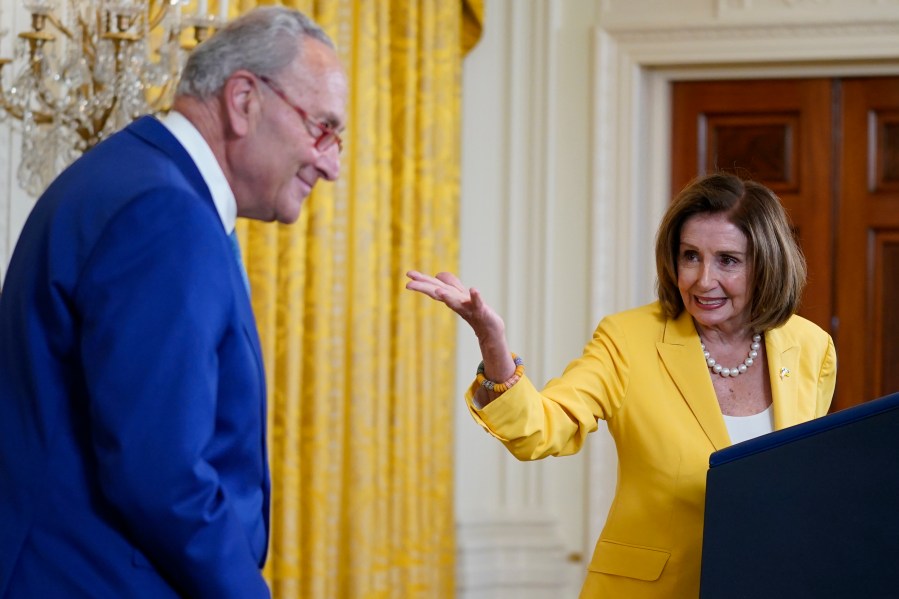 Former Speaker of the House Nancy Pelosi, D-Calif., looks to Senate Majority Leader Chuck Schumer, D-N.Y., as she speaks on the anniversary of the Inflation Reduction Act during an event in the East Room of the White House, Wednesday, Aug. 16, 2023, in Washington. (AP Photo/Evan Vucci)