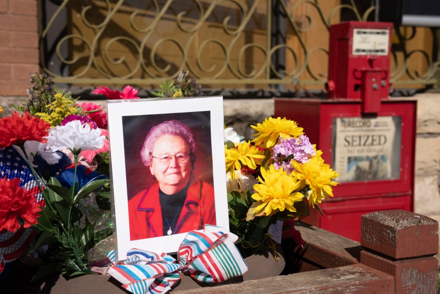 A makeshift shrine is set up in front of the Marion County Record in Marion, Kan. on Saturday, Aug. 19, 2023 with a picture of the newspaper's co-owner Joan Meyer and flowers. (Jaime Green /The Wichita Eagle via AP)