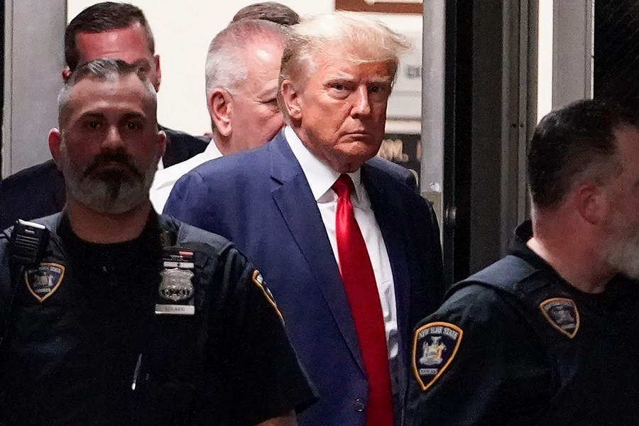 FILE - Former President Donald Trump is escorted to a courtroom, April 4, 2023, in New York. Trump’s bond has been set at $200,000 in the Georgia case accusing the former president of scheming to overturn his 2020 election loss. The bond agreement was outlined in a court filing signed by Fulton County District Attorney Fani Willis and Trump’s defense attorneys. (AP Photo/Mary Altaffer, File)